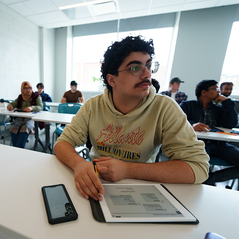 student sitting in class looking at teacher off camera