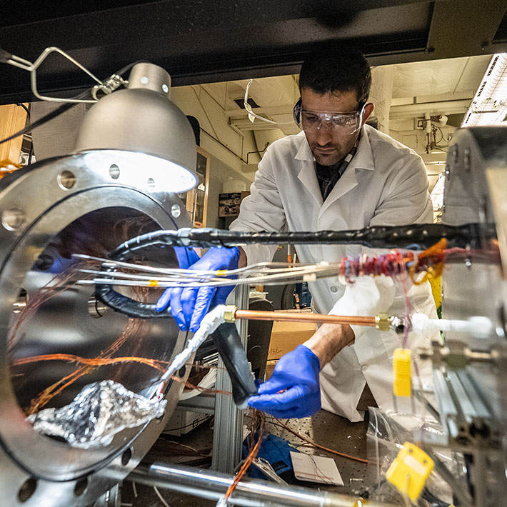 student behind a thermal sciences equipment