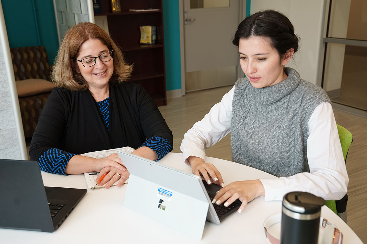 Advisor sitting with student in front of two laptops