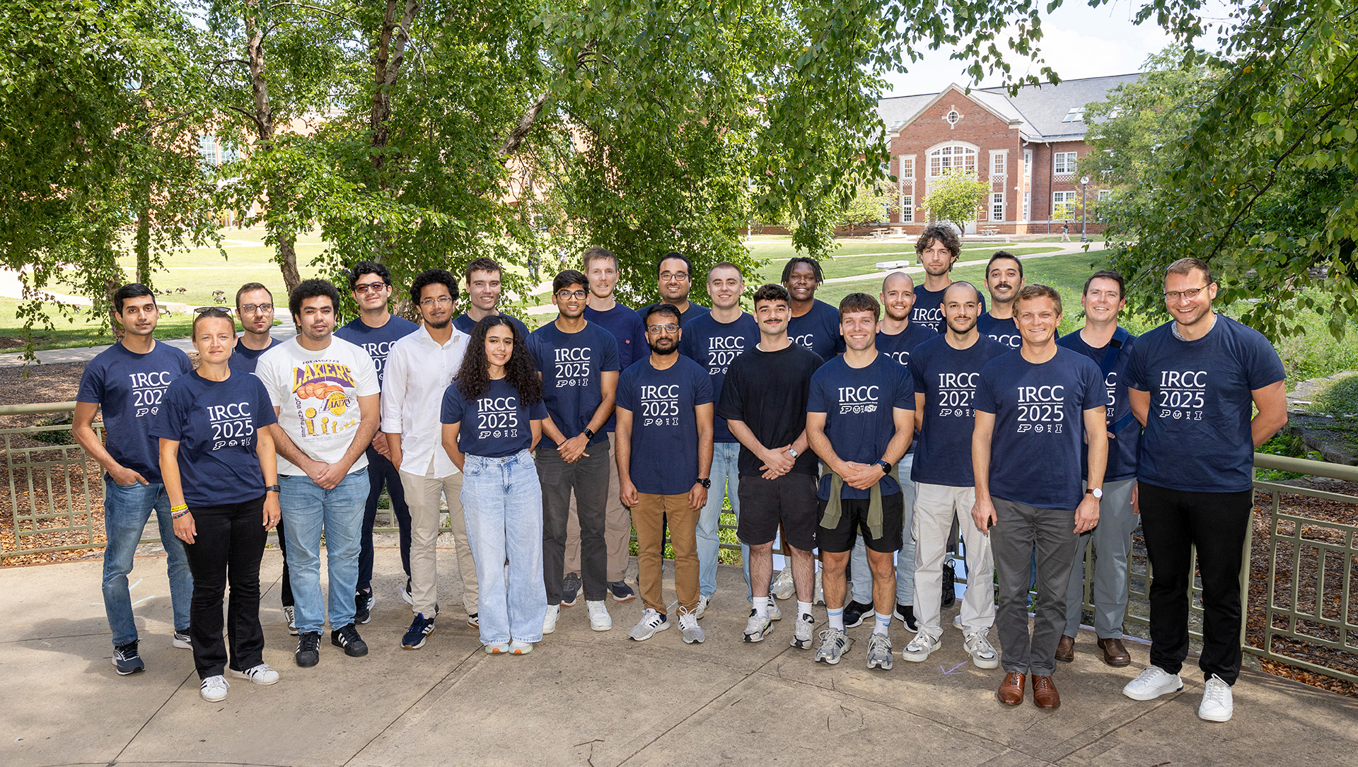 Large group of approximately 25 people standing in front of the Bardeen quad at the University of Illinois Urbana-Champaign