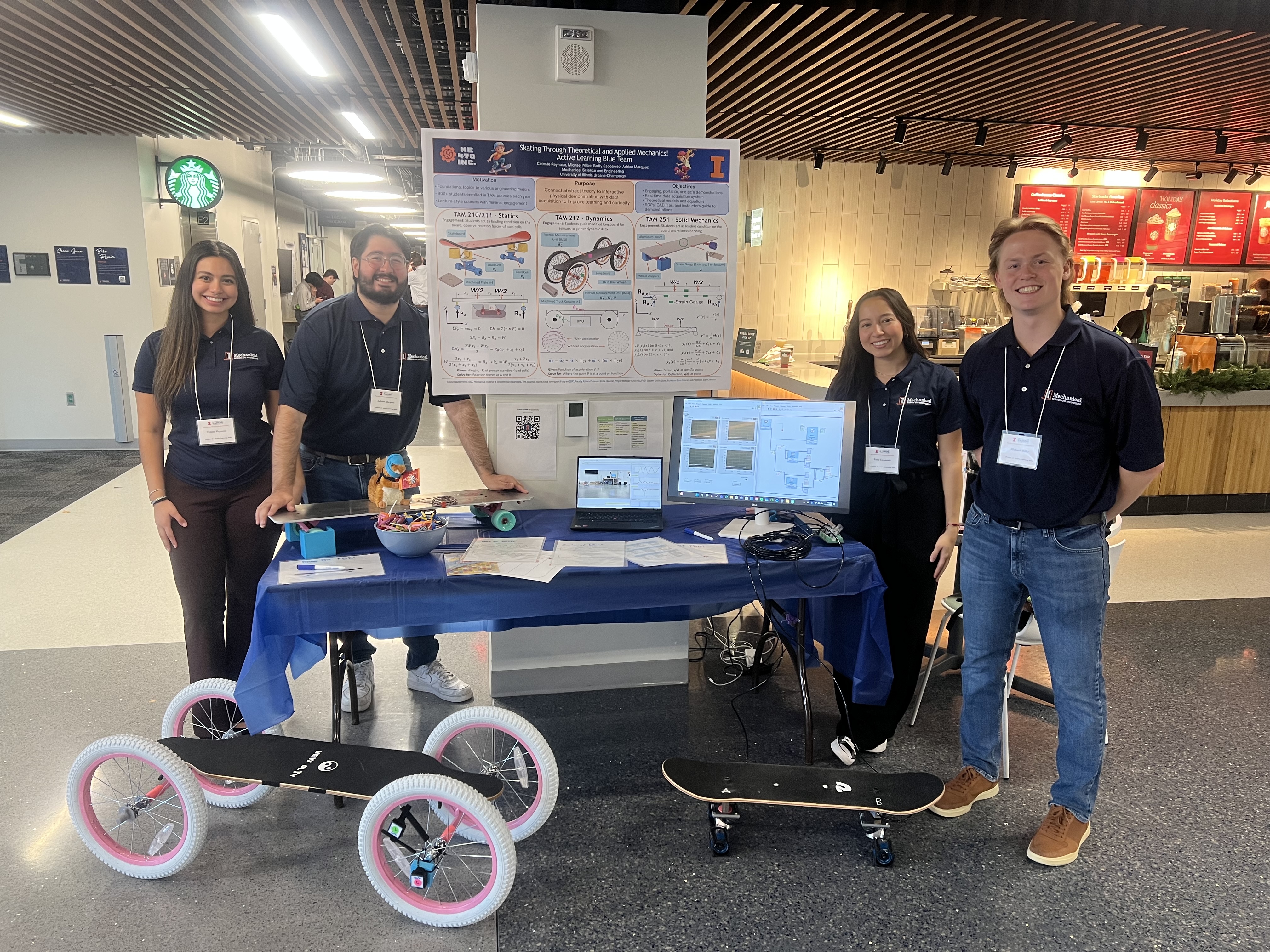 trade show booth with three students and their skateboard prototypes