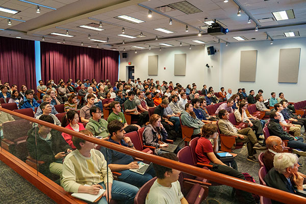 full auditorium of graduate students and faculty listenting to a lecture