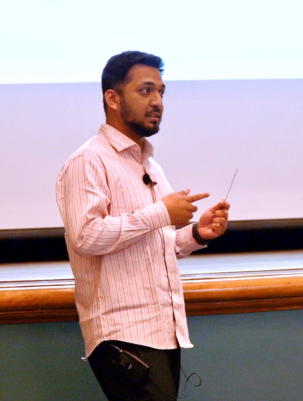 Asif Ahmed presents to an auditorium of people at Gregory Hall.
