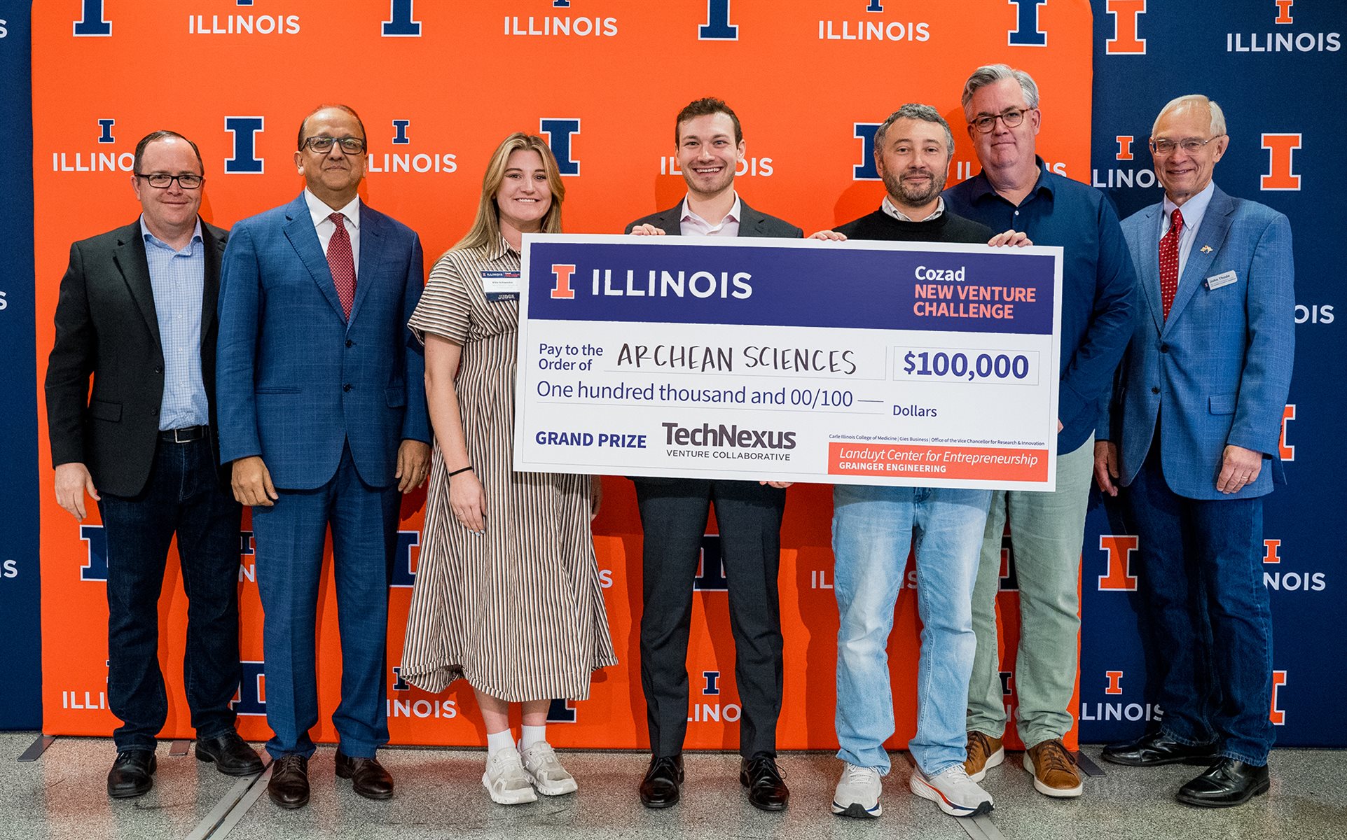 Administrators and student-faculty team hold an oversized check for $100,000 made out to Archean Sciences.