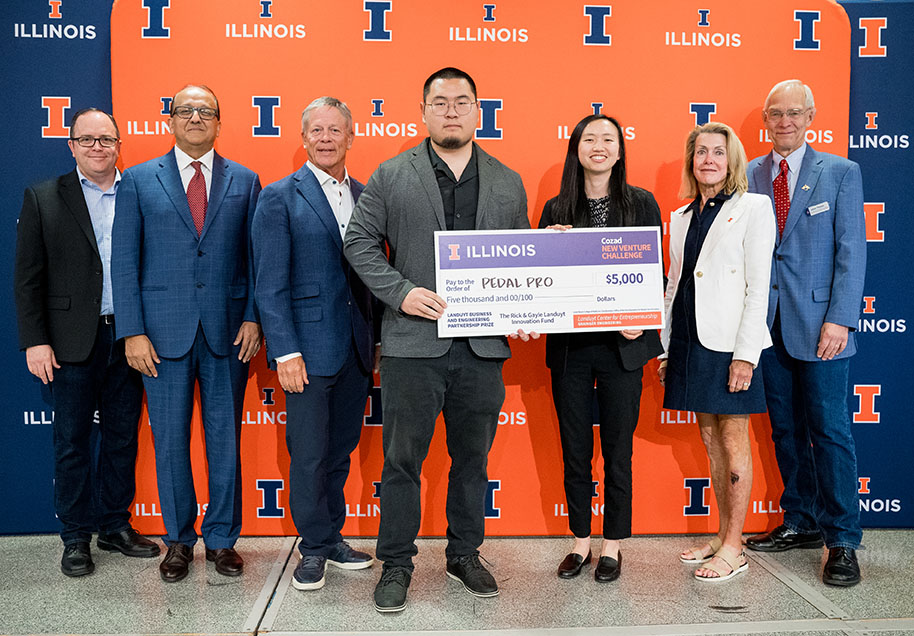 PedalPro team and Cozad administrators holding large check for $5,000