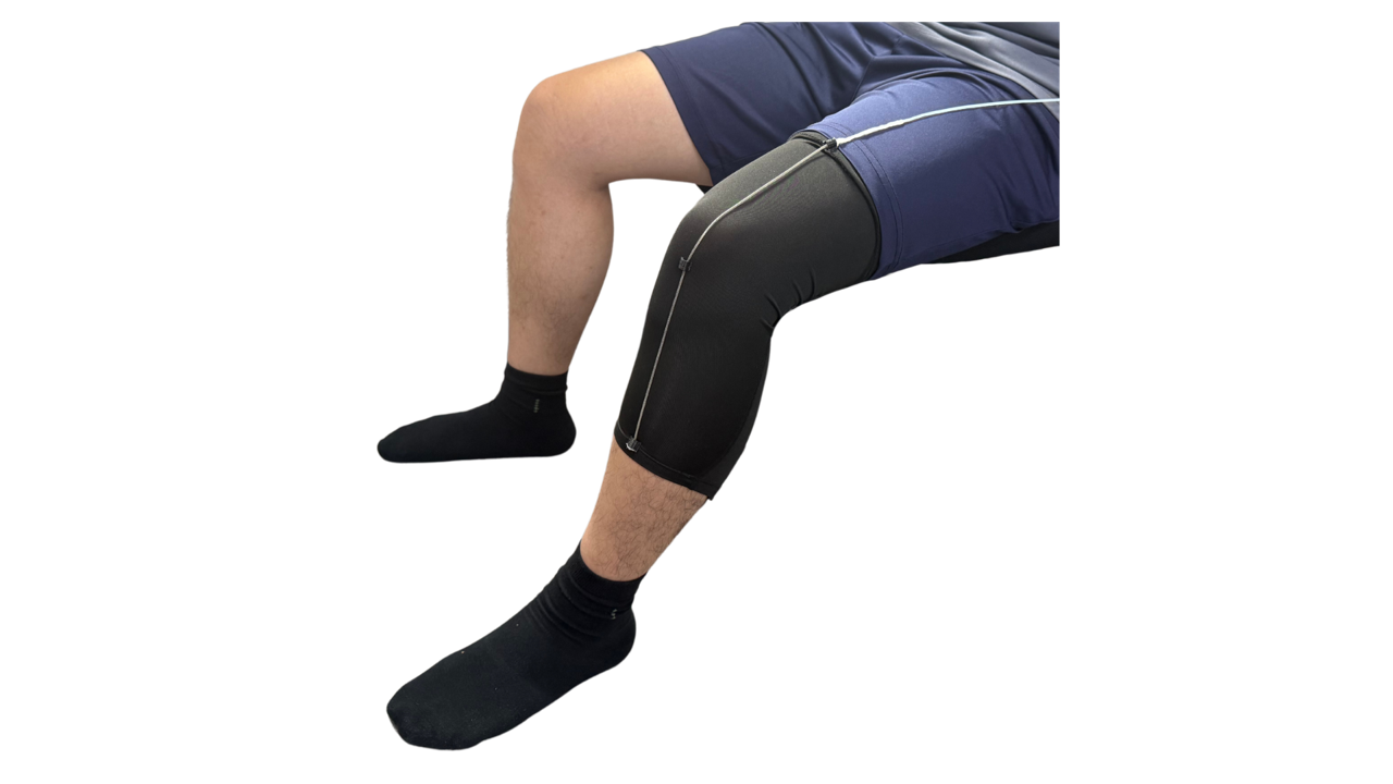 two legs, sitting, one wearing the knee wrap device