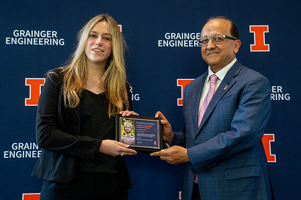 Grace Deane holding a framed certificate alongside Grainger Engineering dean Rashid Bashir