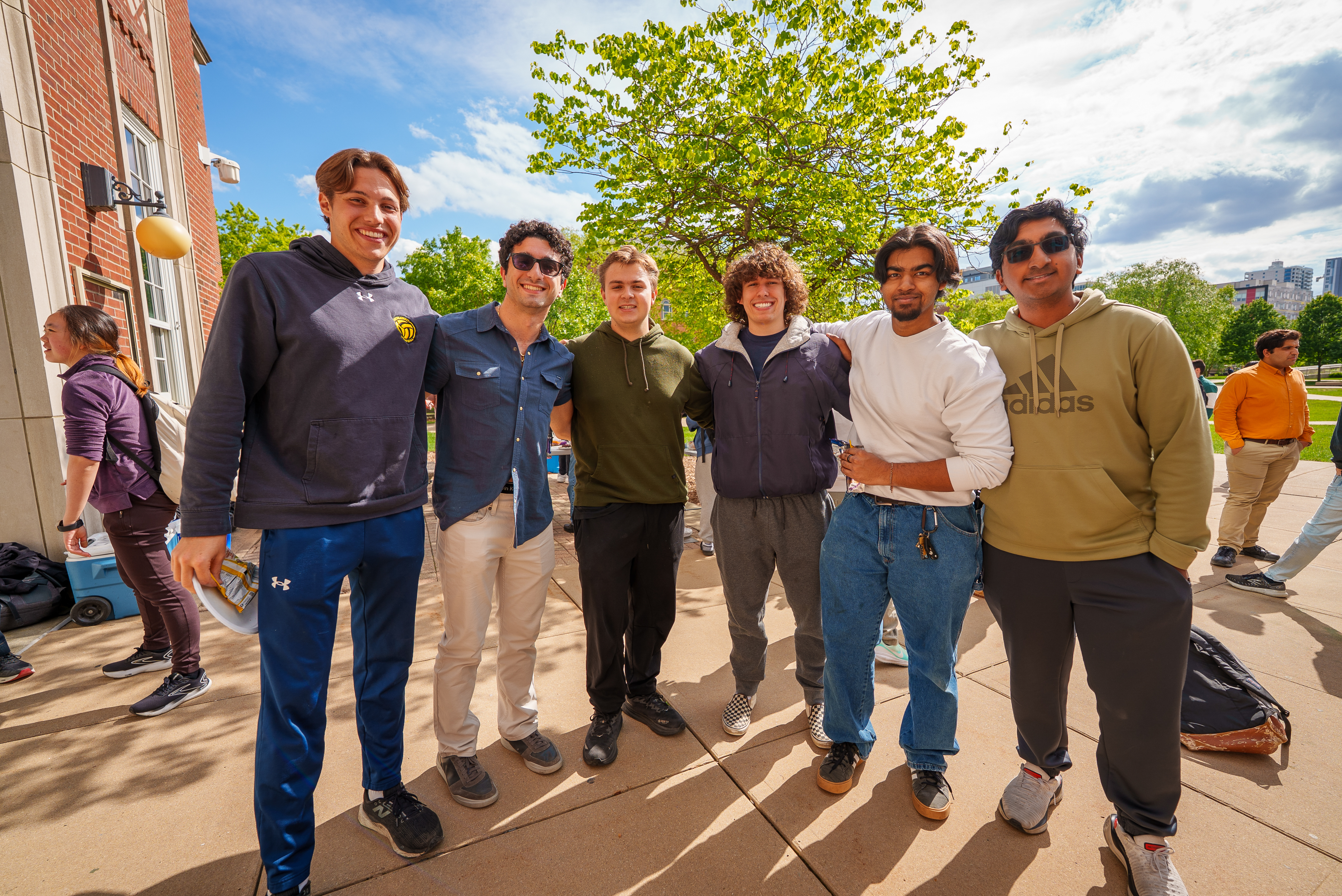 Six male undergraduate students standing in a row smiling at the camera.