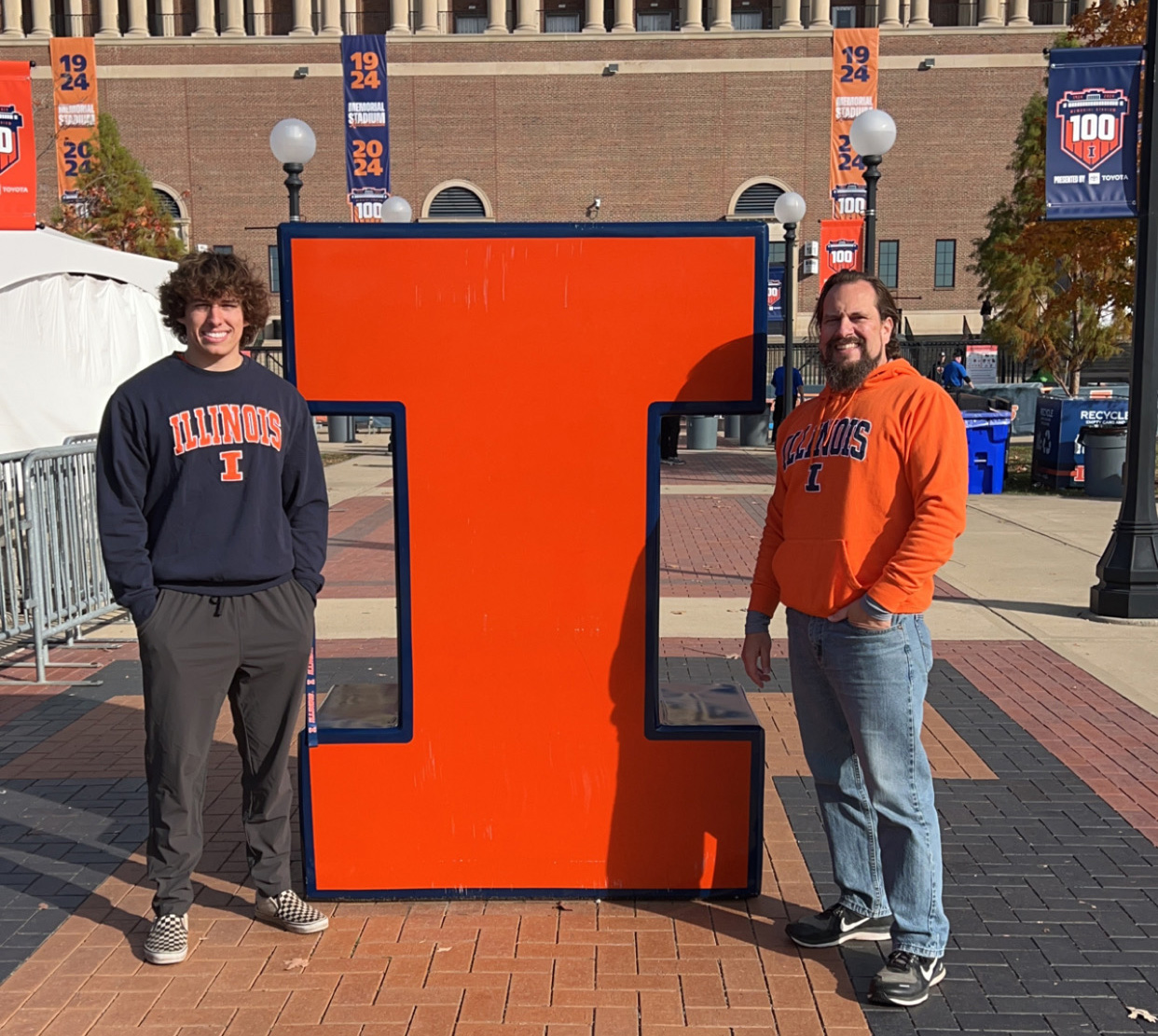 Evan and Darren Tonarelli by a large Block I at Memorial Stadium