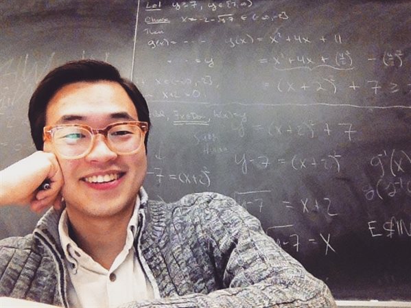 Grad student in front of chalkboard.