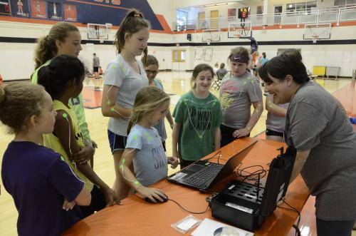 Kersh (at right) organized activities for girls attending basketball camp on the U of I campus. She explains how electromyography is used to measure muscle activation. (Photo by Elizabeth Renee Livingston)
