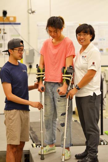 Graduate student Chenzhang Xiao, left, and Hsiao-Wecksler, right, demonstrate their energy-harvesting mechanism within the crutch.