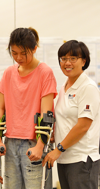 Professor Elizabeth Hsiao-Wecksler (right) tests a powered orthotic for forearm support.