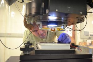 Postdoc Kyle Jacobs works with the S4 machine during stamp manufacturing. On the hot plate is a silicon mold with nanoscale patterns. Above is the glass S4 stamp that has been imprinted at about 100ËšC to transfer the pattern to the stamp. The next step in the process would be to press the stamp against a silver film and apply a small voltage, etching the silver and leaving behind replicas of the nanoscale patterns. 