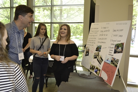 Muskin (left) listens to a Centennial student explain her team's research. 