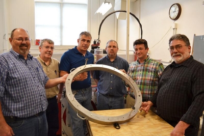 MechSEâ€™s Machine Shop staff created this lens holder to ensure safe transport of a massive lens being taken to the South Pole for an Illinois astronomy professorâ€™s telescope. From left: Gary Sedberry, Jeff Smith, Dave Williams, Kyle Cheek, Damon McFall, and Cliff Gulyash.