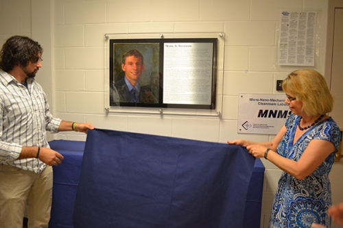 Mona Shannon and son Davis unveil the painting and plaque of Mark Shannon.