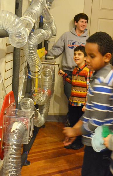 A Uni High student showing young kids how the Orpheum air maze works.