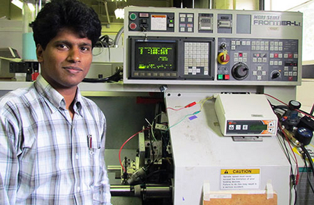 Chandra Nath stands next to his atomization-based cutting fluid spray system.
