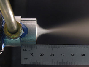 A thin layer of cutting fluid from the atomized droplets penetrates the tool-chip interface.