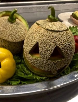 Cantaloupe in the Ike carved like a jack-o-lantern for Halloween.