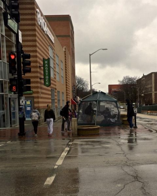 Girl Scouts sell cookies inside a tent on a rainy day on the corner of Wright and Green.