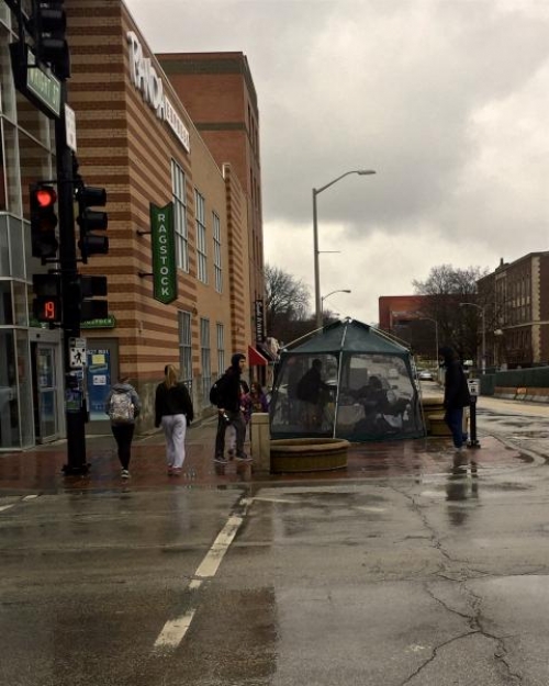 Girl Scouts sell cookies inside a tent on a rainy day on the corner of Wright and Green.