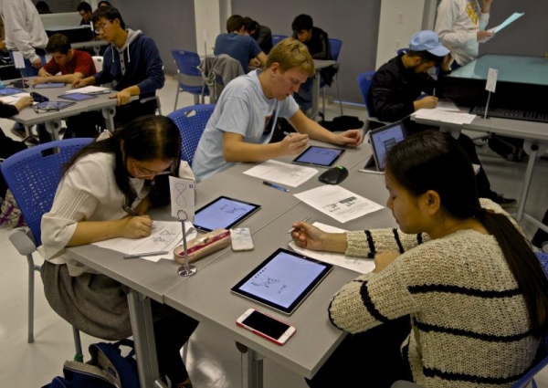 TAM 210 students having a discussion in the IDEALL research lab run by Emma Mercier from the College of Education.