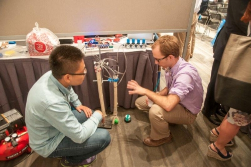 Xiaotian Zhang (left) demonstrates his team's robot design. 