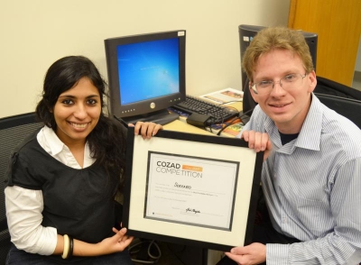 Nishana Ismail and Tim Deppen showing the Cozad award they won early in Shadow's development.