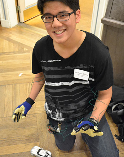 Michael Duong (Aero) poses with his robotic-sensor gloves and remote-control car he developed with teammate Mateusz Jedryczka (ECE). 