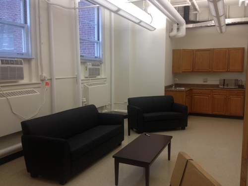 Lounge furniture with kitchen in the background.