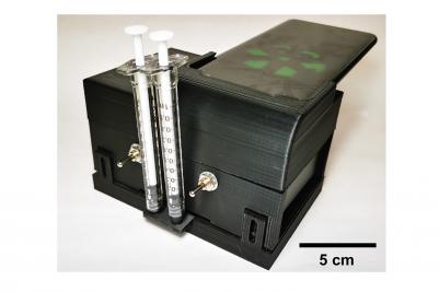 The microfluidic cartridge can be inserted into a portable device that also has a cradle for a smartphone, so the phoneâ€™s camera can read the test results. Photo courtesy of Bill King