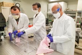 Mechanical science and engineering professor Taher Saif, right, and students Onur Aydin, left, and Bashar Emon test common household fabrics used to make masks to help stop the spread of the coronavirus.  Photo courtesy Taher Saif.
