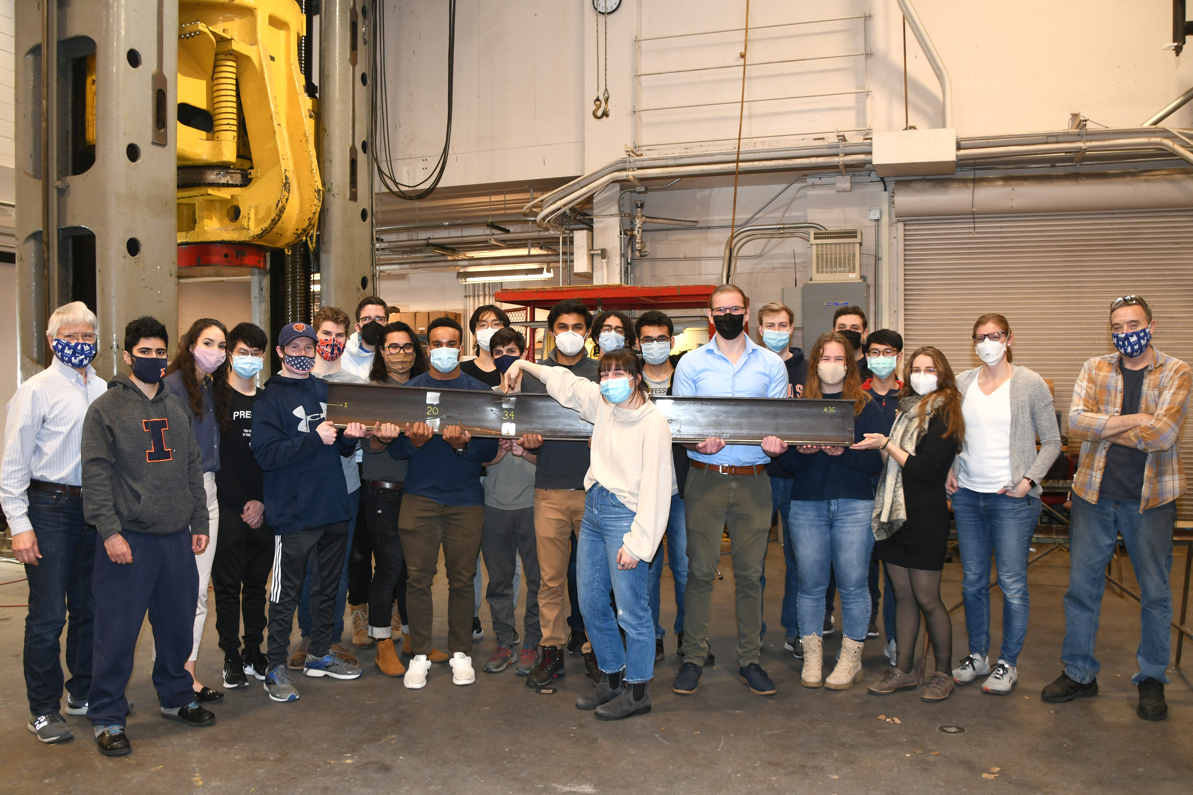 Students holding large beam.