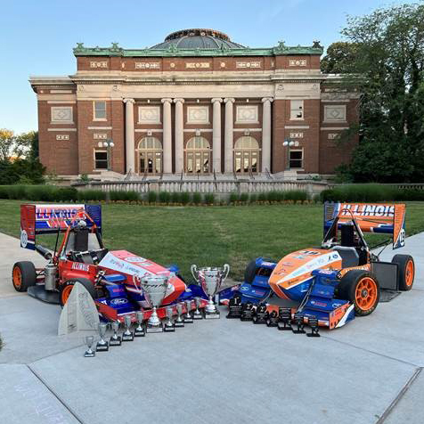 Formula SAE cars with trophies on Quad in front of Foellinger Auditorium