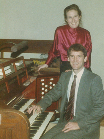 Bill Bahnfleth and his wife sitting at an organ smiling at the camera.