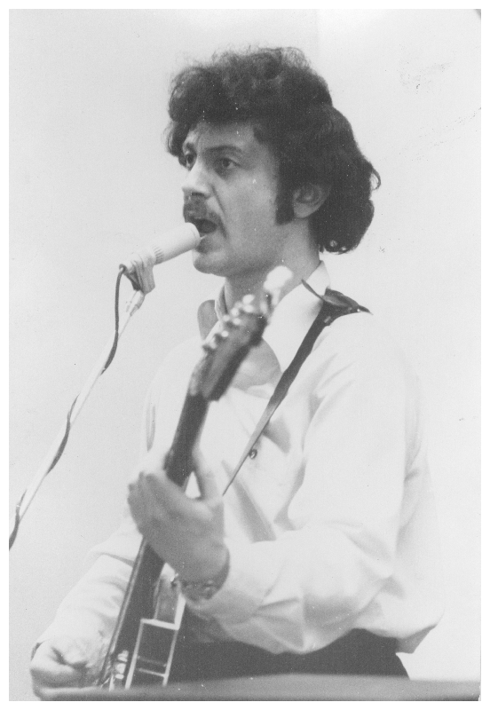 Joseph Bentsman playing guitar and singing. Black and white photo from the 1970s.