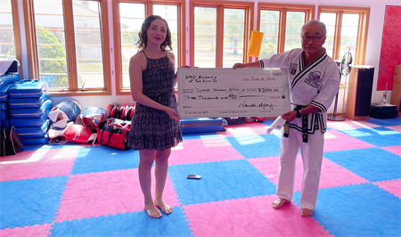 Asena with large check with martial arts instructor