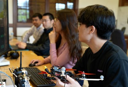 grad students working with drones in a lab