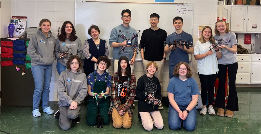 group of middle schoolers, graduate students, and Naira Hovakimyan pose with their drones