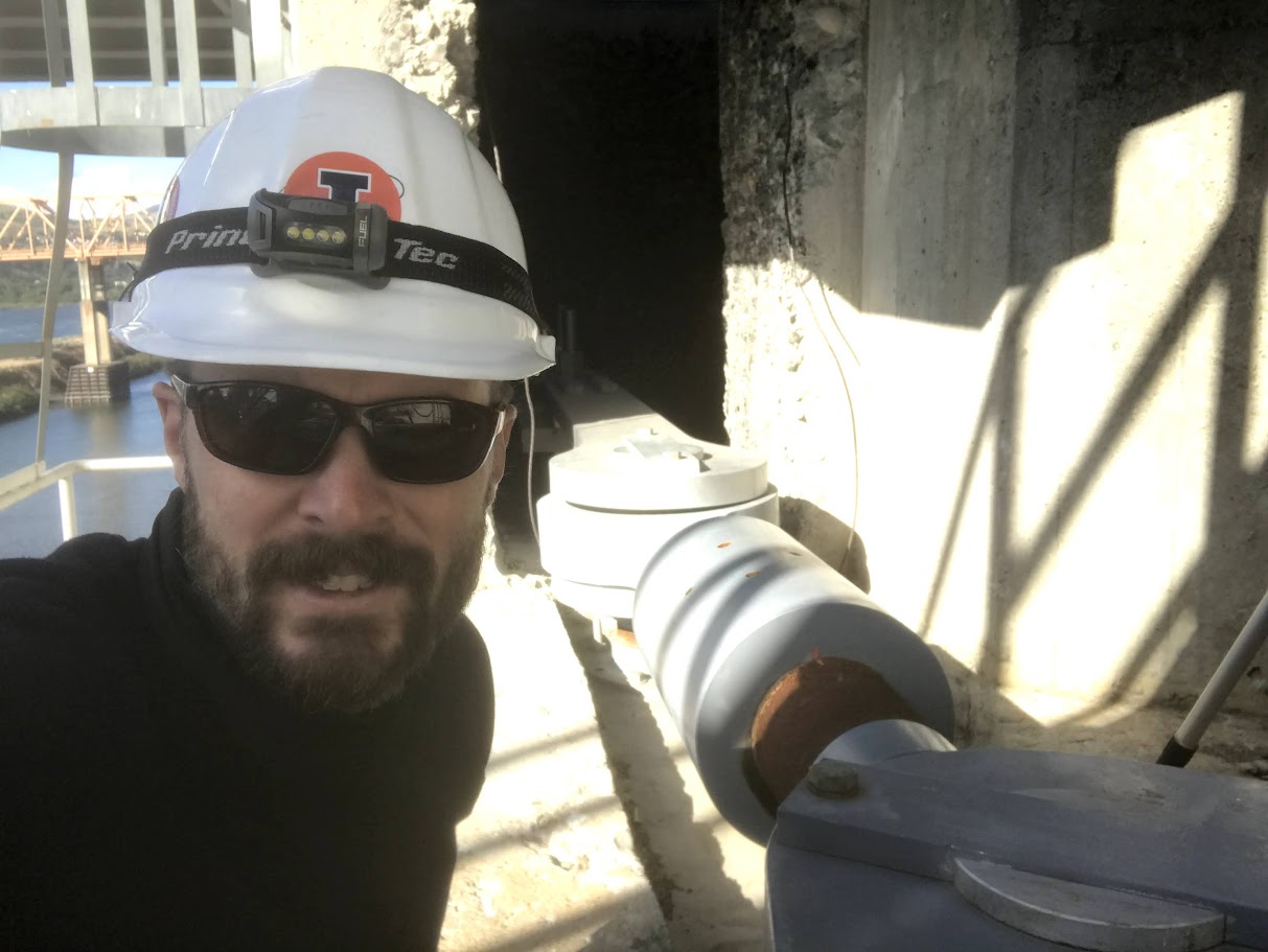 Tom Golecki in a construction hat looking at the camera.