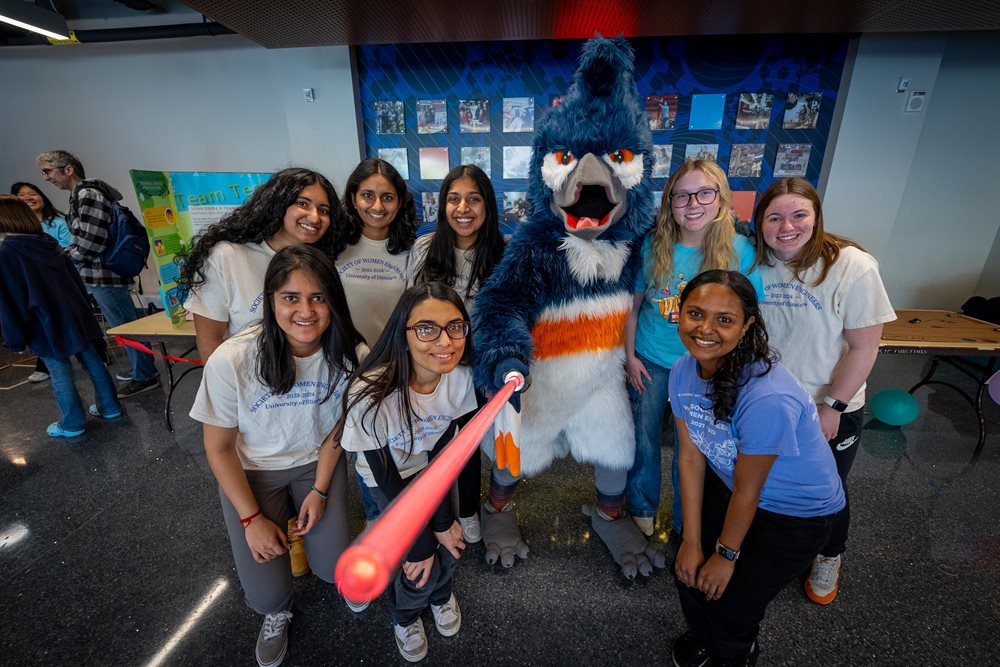 Mascot posing with group of women students