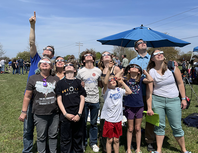 family looking at solar eclipse