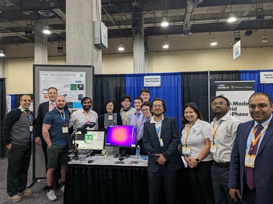 Group photo at a booth in an exhibit hall.