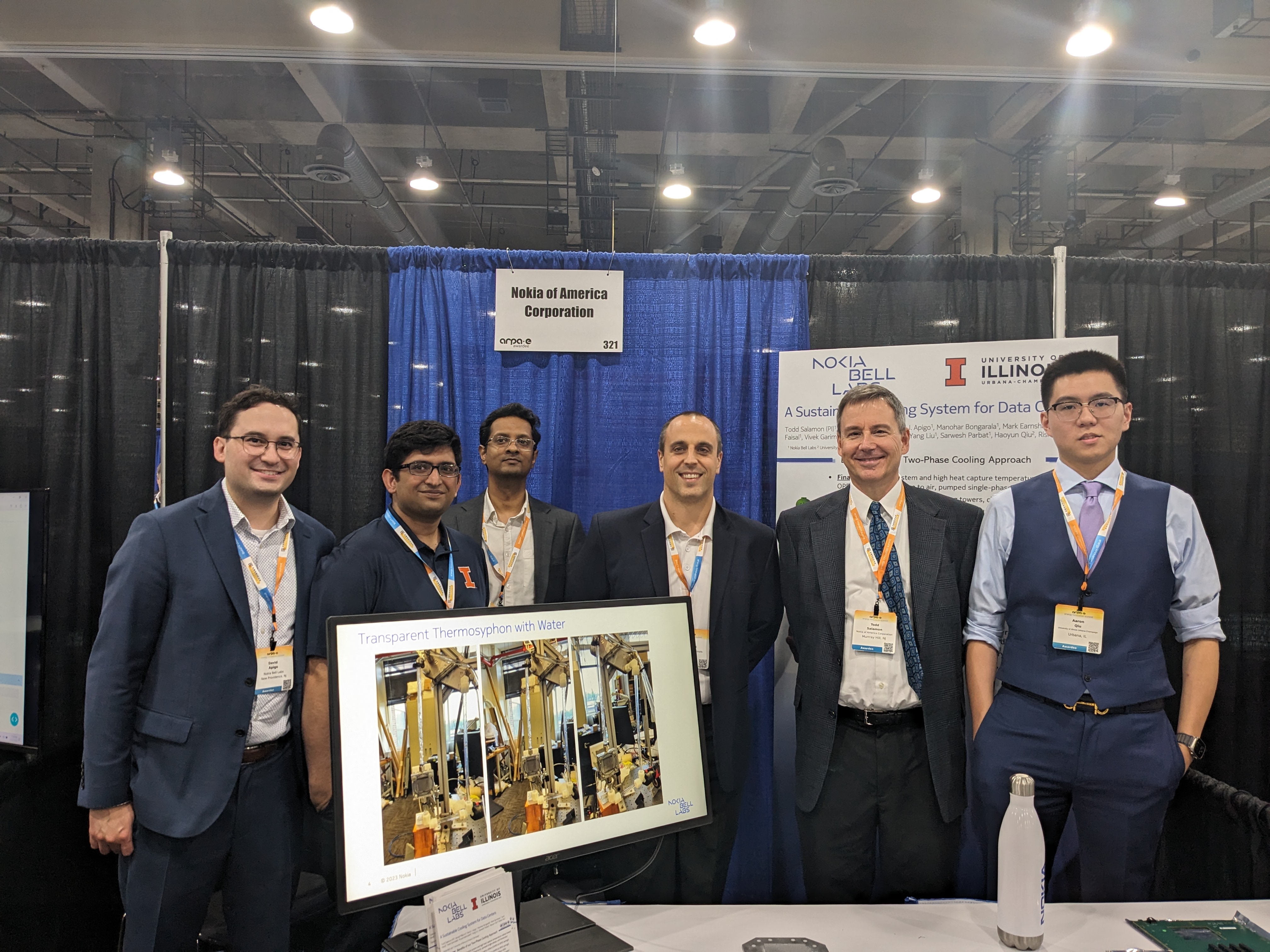 Group photo at a booth in an exhibit hall.