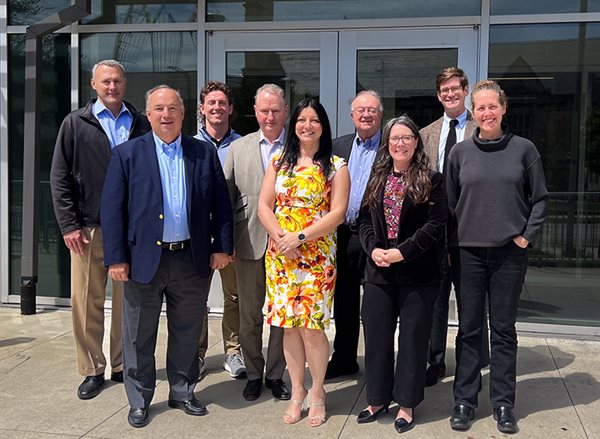 alumni board members standing outside in front of the main doors of Sidney Lu Mechanical Engineering Building